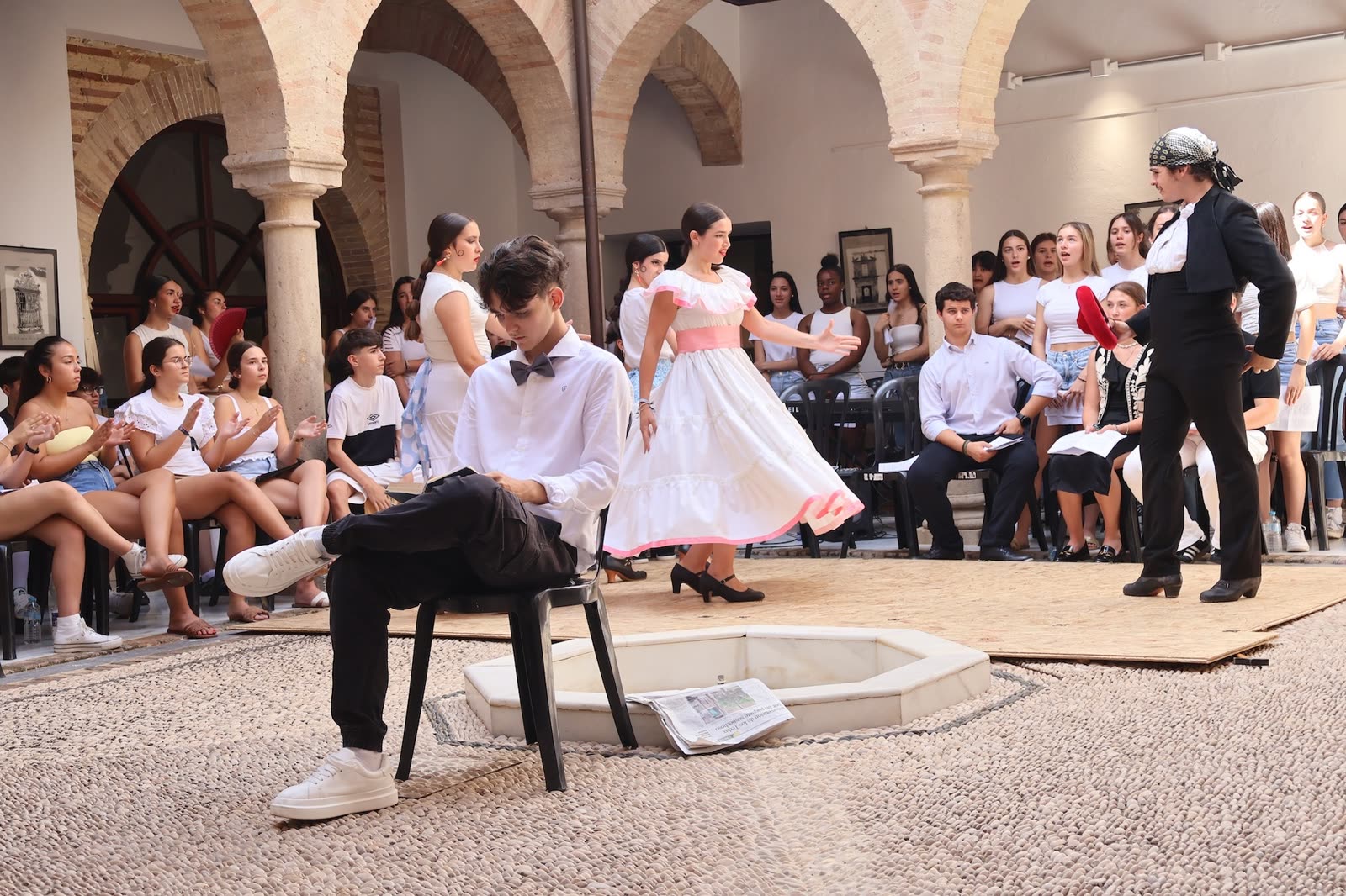 Intérprete en primer plano con coro e instrumentistas al fondo